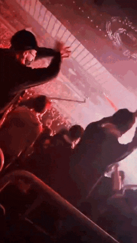 a man in a black hat is dancing in a crowd of people at a concert .