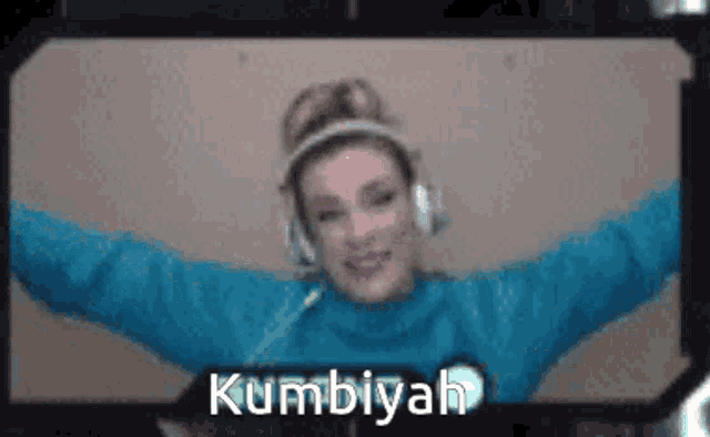 a woman wearing headphones and a blue sweater with the name kumbiyah written on the bottom