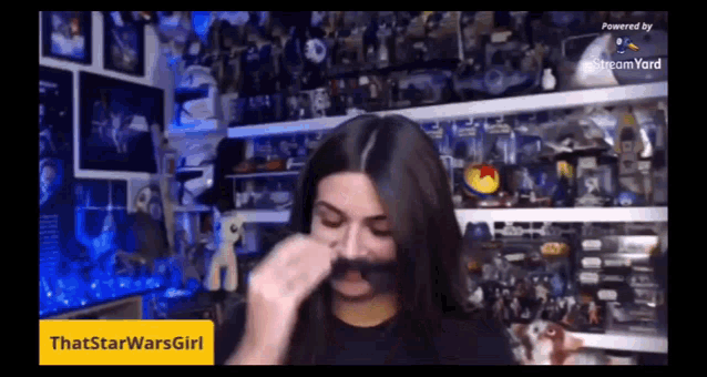 a woman is making a fake mustache in front of a stream yard sign