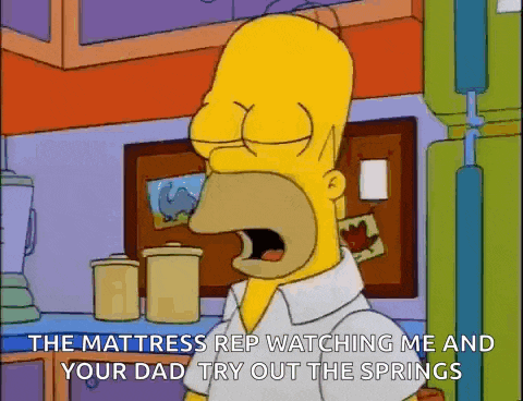 homer simpson from the simpsons is yawning in a kitchen while looking at the mattress .