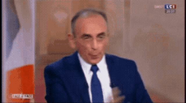 a man in a suit and tie is talking on a television screen