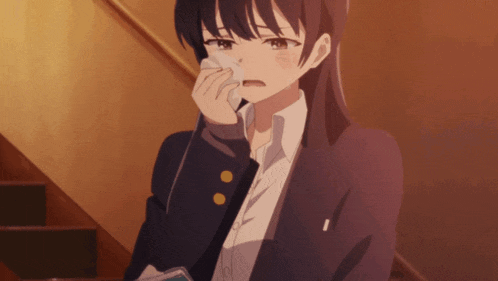 a girl in a school uniform is crying while holding a napkin