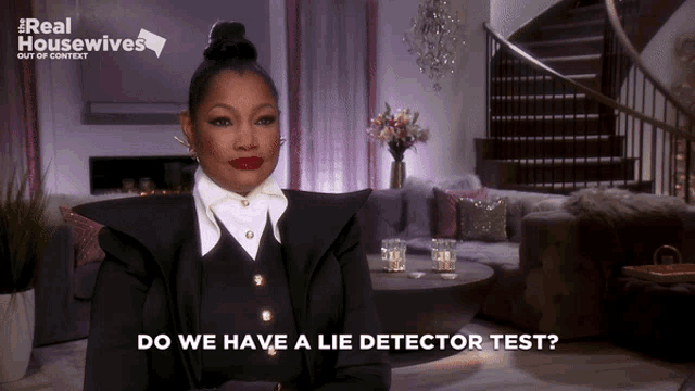 a woman sitting in a living room with the words " do we have a lie detector test " on the screen