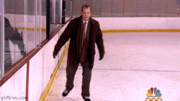 a man in a suit and tie is skating on a rink with a nbc logo in the background