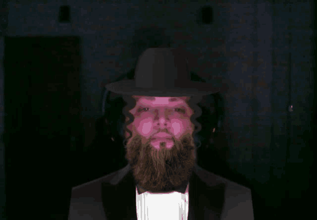 a man with a beard is wearing a black hat