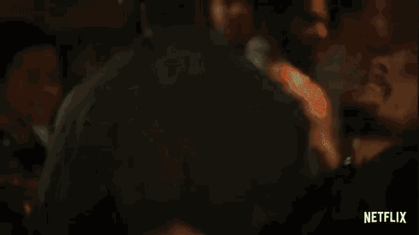 two men are standing next to each other in a dark room .