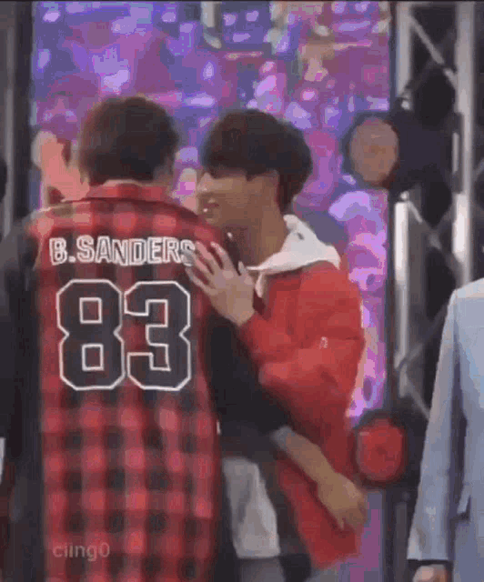 a couple of men are hugging each other in front of a stage .