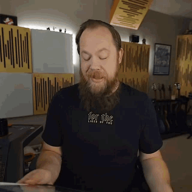 a man with a beard wearing a black shirt that says for the likes of you