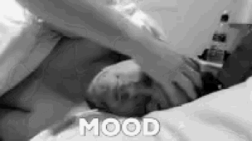 a black and white photo of a person laying on a bed with the word mood written on the bottom