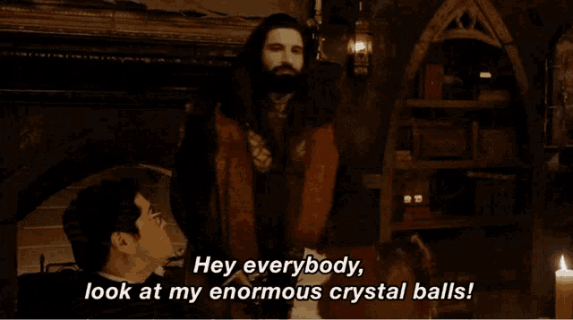 a man is holding a crystal ball and saying hey everybody look at my enormous crystal balls