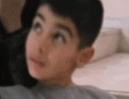 a close up of a young boy 's face with a blurred background