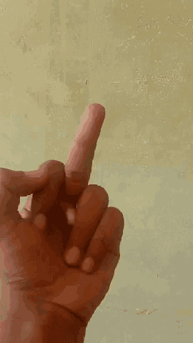 a person 's hand is giving the middle finger