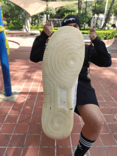 a person wearing a champion hat is kicking the bottom of a shoe