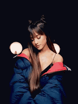 ariana grande is wearing a blue puffer jacket with a red collar .