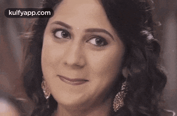 a woman is smiling and looking at the camera .