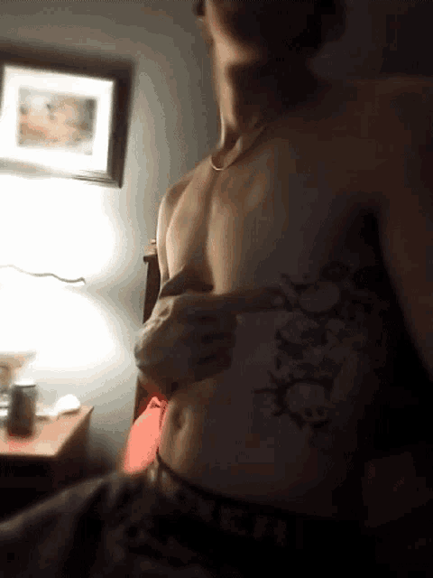 a shirtless man with a tattoo on his chest that says ' x '