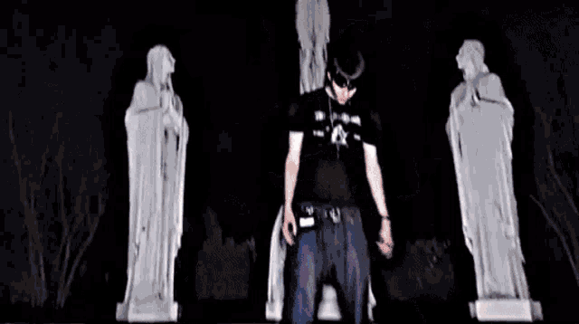 a man in a black shirt is standing in front of a statue