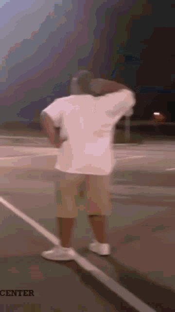 a blurry picture of a man standing on a basketball court with the words center in the corner