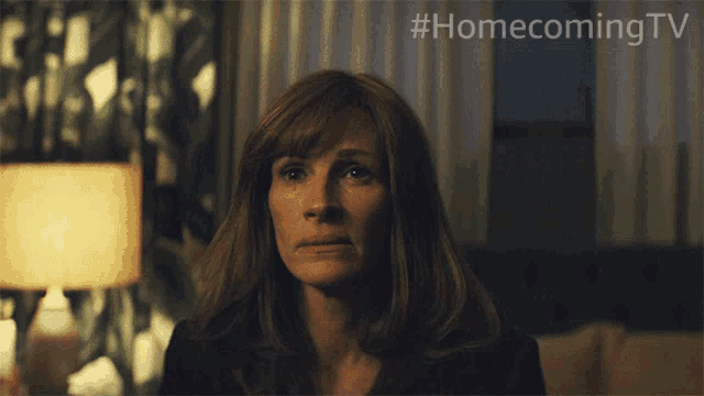 a woman is crying in front of a sign that says # homecoming tv