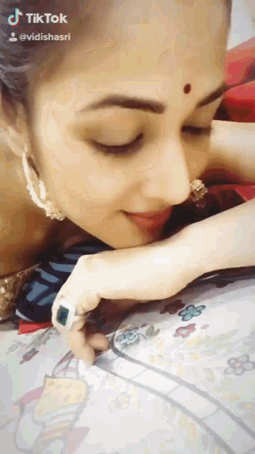 a tiktok video of a woman with a red dot on her nose