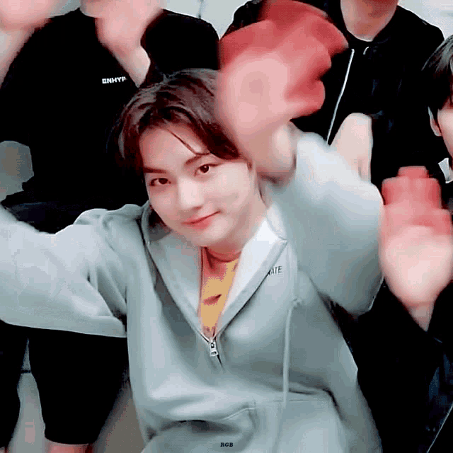 a boy wearing a gray hoodie with the word enhyp on it