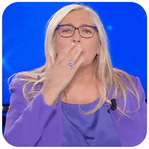 a woman wearing glasses is blowing a kiss