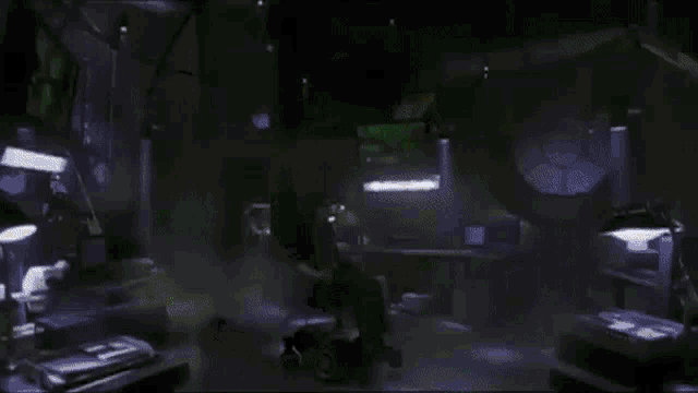 a woman sits in a chair in a dark room with a green light behind her