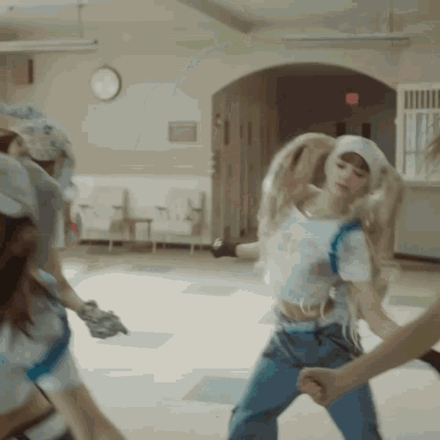 a group of people dancing in a room with a red exit sign