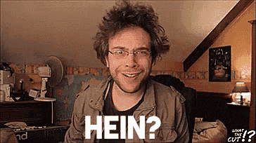 a man wearing glasses and a brown jacket is smiling and says hein ?