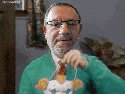 a man with glasses and a beard is holding a stuffed animal with the word vagonetas on the bottom right