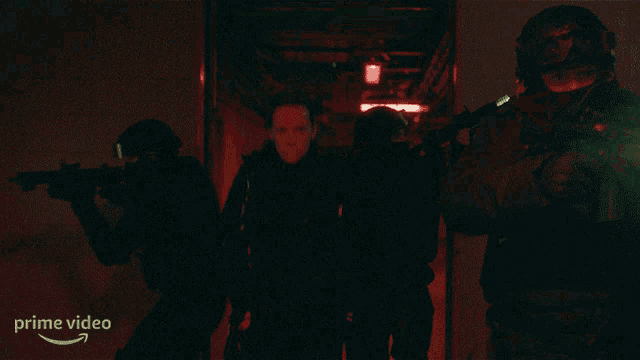 a group of people standing in a dark room with a prime video logo on the bottom right