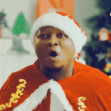 a man is wearing a santa hat and a cape that says ' merry ' on it