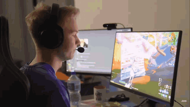a man wearing headphones is sitting in front of a computer monitor