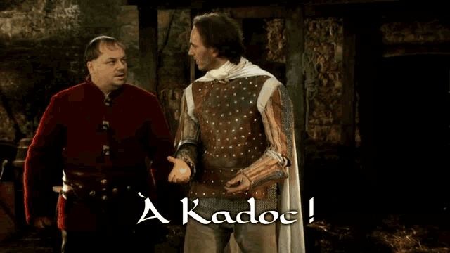 two men are standing next to each other and the words a kadoc are on the screen