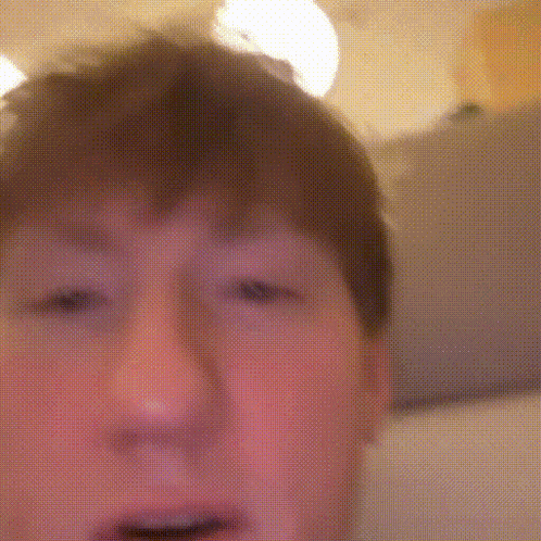 a close up of a young boy 's face with a blurred background