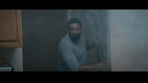 a man in a kitchen is holding a broom in his hands