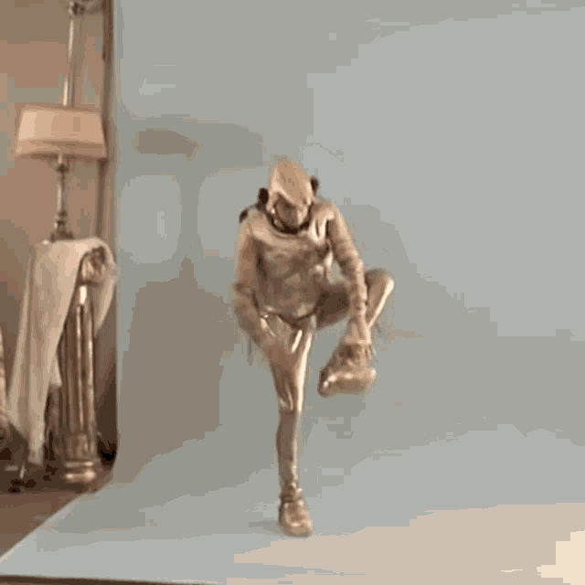 a man in a gold costume is standing in front of a lamp