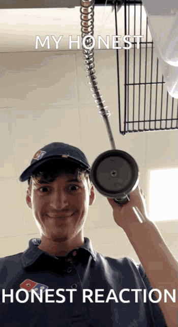 a man in a domino 's uniform is holding a cup in front of a sign that says " my honest honest reaction "