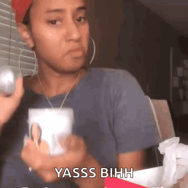 a woman is holding a cup in her hand with the words yasss bihhh on the bottom