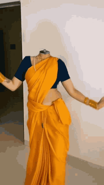 a woman without a head is wearing a yellow saree and a black blouse
