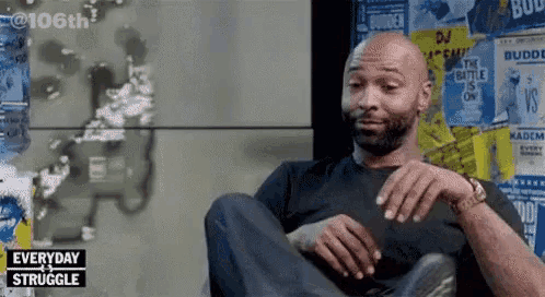 a man is sitting in front of a wall with posters on it and the words everyday struggle