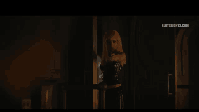 a woman with pink hair is standing in a dark room and says ben maria kyle 'in kiziyum