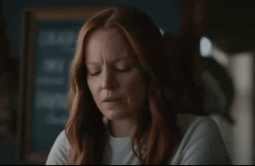 a woman with red hair is looking at something
