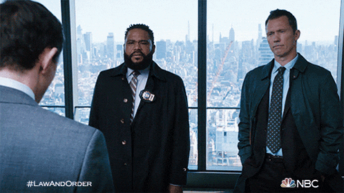 two men in suits and ties are standing in front of a window with the words law and order written on the bottom