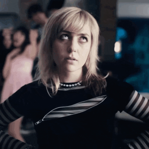 a woman wearing a black and grey striped shirt with a zipper on the front