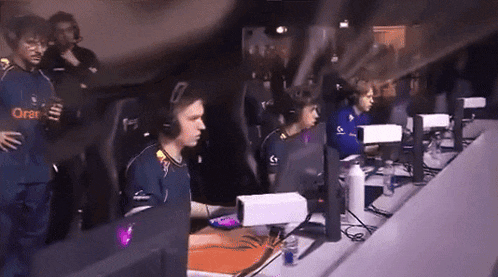 a group of people are playing a video game and one of their shirts has the word orange on it