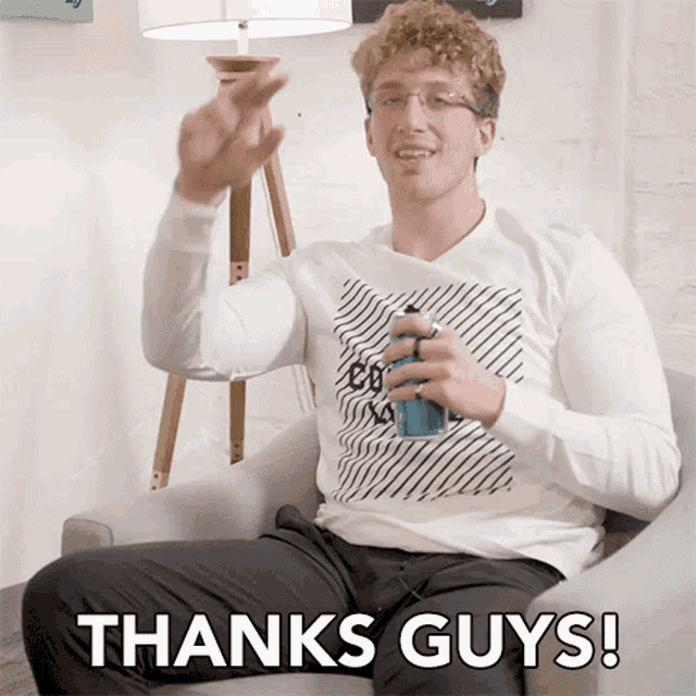 a man is sitting in a chair with a can of soda in his hand and says thanks guys