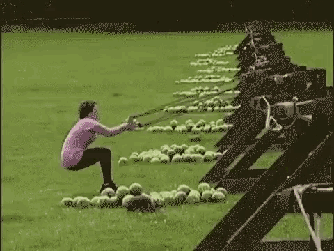 a woman is squatting down in a field of watermelons .