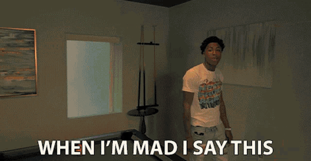 a man is holding a microphone in front of a pool table and says when i 'm mad i say this