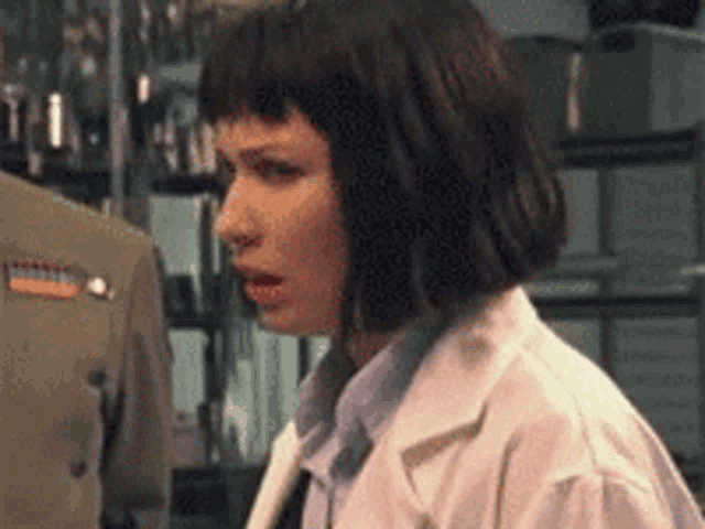 a woman in a white lab coat is standing in front of a man in a military uniform
